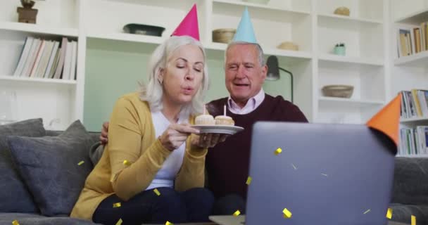 Animatie Van Confetti Vallen Senior Paar Feestmutsen Laptop Videogesprek Wereldwijd — Stockvideo