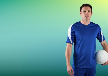 Beyaz erkek futbolcu yeşil gradyan arka planda fotokopi alanına karşı futbol topu tutuyor. Spor yarışması ve turnuva konsepti