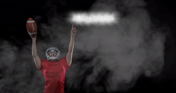 Male Rugby Player Holding Ball Pointing Stadium Lights Smoke Black — Stock Video