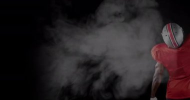 Animation of smoke over male american football player with ball. sport and celebration concept digitally generated video.