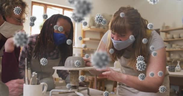 陶器製ホイールに取り組む多様な女性陶芸家のグループに対するCovid 19細胞の複合ビデオ 陶器とCovid 19パンデミックの概念 — ストック動画