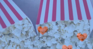 Patlamış mısır kutularının üzerinde kalp ikonlarının canlandırılması. patlamış mısır günü ve dijital olarak üretilen video konsepti.