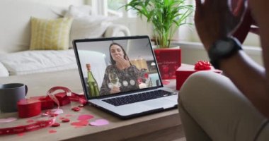 Şaraplı mutlu beyaz kadın dizüstü bilgisayarında Sevgililer Günü videosu çekiyor. Sevgililer Günü kutlaması, lgbtqi, romantizm ve iletişim teknolojisi.
