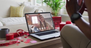 Kafkasyalı mutlu bir kadın el sallıyor ve sevgililer günü videosunu dizüstü bilgisayarında çekiyor. Sevgililer Günü kutlaması, lgbtqi, romantizm ve iletişim teknolojisi.