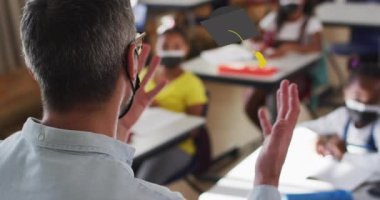 Çeşitli okul çocukları ve yüz maskesi takan öğretmenlerin mezuniyet başlığı simgelerinin canlandırılması.