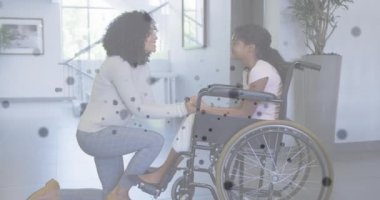Afrika kökenli Amerikalı anne ve kızının tekerlekli sandalyedeki bağlantılarının animasyonu. küresel tıp, engellilik, sağlık ve teknoloji konsepti dijital olarak oluşturulmuş video.