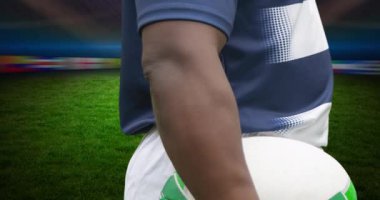 Afrika kökenli Amerikalı erkek rugby oyuncusunun stadyumun üzerinde topu tutuşu. spor ve yarışma konsepti dijital olarak oluşturulmuş video.