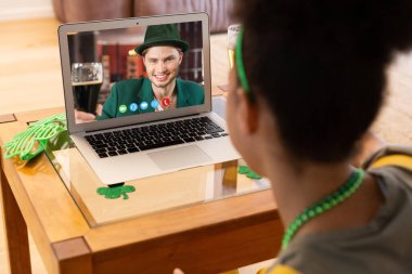 Afro-Amerikalı bir kadının evinde dizüstü bilgisayarından bir video görüşmesi var. Aziz Patrick 'in kutlama konsepti