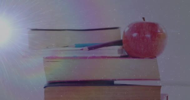 Animation Von Lichtfleck Über Büchern Und Apfel Auf Weißem Hintergrund — Stockvideo