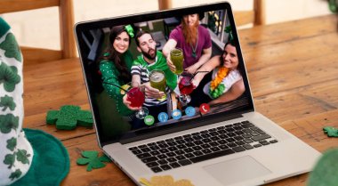 Webcam görüntüsü, bir grup arkadaşın, ahşap masada dizüstü bilgisayardan içki içerken görüntülerini gösteriyor. Aziz Patrick 'in kutlama konsepti