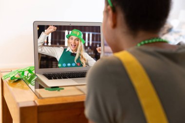 Afro-Amerikalı bir kadının evinde dizüstü bilgisayarından bir video görüşmesi var. Aziz Patrick 'in kutlama konsepti