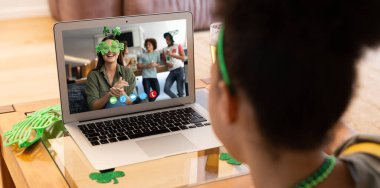 Afro-Amerikalı bir kadının evinde dizüstü bilgisayarından bir video görüşmesi var. Aziz Patrick 'in kutlama konsepti