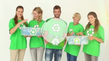 Geri dönüşüm kutularıyla gülümseyen beyaz gönüllülerin üzerine dünyanın animasyonu. Toprak günü ve dijital olarak üretilen video konsepti.