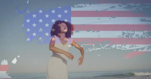 Animación Bandera Americana Sobre Mujer Afroamericana Levantando Las Manos Playa — Vídeos de Stock