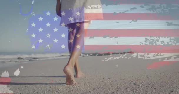 Animación Bandera Americana Sobre Mujer Afroamericana Caminando Playa Patriotismo Concepto — Vídeos de Stock