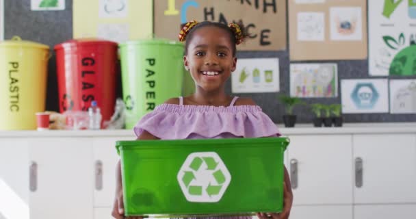Animacja Recyklingu Zielonych Znaków Nad Afrykańską Amerykańską Dziewczyną Trzymającą Zielone — Wideo stockowe