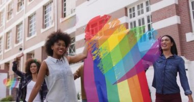 Gösteride lgbtq bayrağı tutan farklı insanların üzerinde gökkuşağı bayraklarının videosu. lgbtq, insan hakları ve eşitlik kavramı dijital olarak oluşturulmuş video.