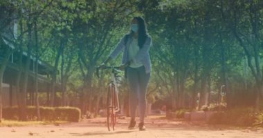 Yüz maskeli, bisikletli, melez bir kadının canlandırması. Dijital olarak üretilen video pandemik konsept covid 19 sırasında pedal günü ve kutlama.