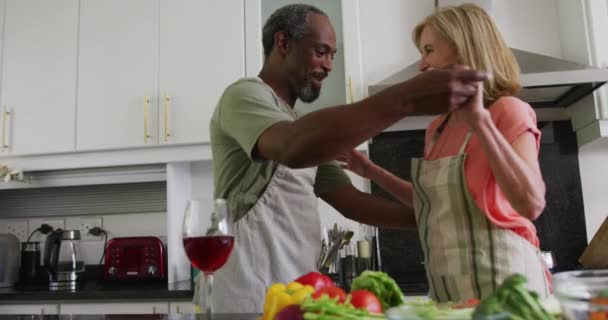 Vídeo Flores Brancas Sobre Casal Diversificado Sênior Dançando Cozinha Aposentadoria — Vídeo de Stock