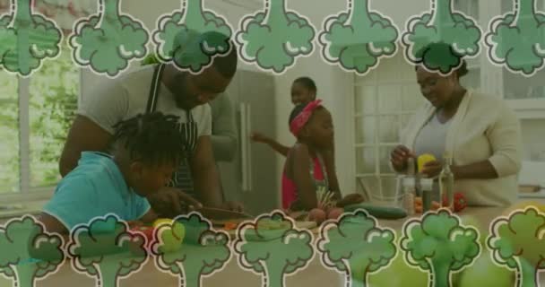 非洲裔美国家庭在厨房里一起做饭时 蔬菜的动画飘落在他们的头上 家庭品质时间 烹调及食物概念数码录影 — 图库视频影像