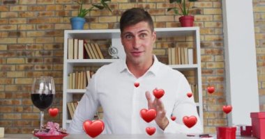 Kafkasyalı bir adamın video görüşmesinde evlenme teklif etmesi üzerine kırmızı kalplerin animasyonu. Sevgililer Günü, aşk ve romantizm konsepti dijital olarak oluşturulmuş video.