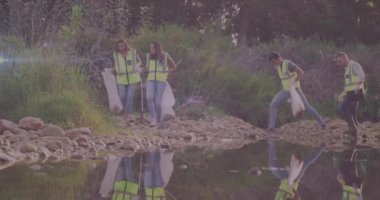 Kırsal kesimdeki çöpleri temizleyen mutlu grup üzerinde hareket eden ışıkların videosu. Çevre koruma gönüllü ayı dijital video.