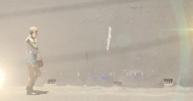 Melez bir kadının işe giderken sokakta akıllı telefon kullandığı renkli ışıkların videosu. İşe yürüyerek gidildiği gün, banliyö sakinleri dijital olarak oluşturulan videoda hareket halindeler.