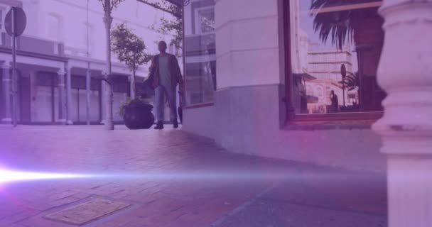 视频上的彩灯笼罩着一个走在大街上提着手提箱去上班的白人男子 步行上班 通勤的人在城市里走来走去 用数字方式制作视频 — 图库视频影像