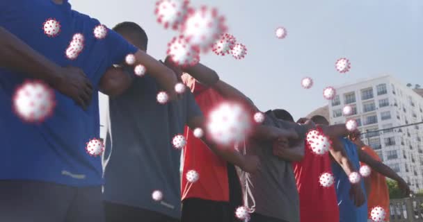 男性サッカー選手の多様なグループに浮かんでウイルス細胞のアニメーションを受け入れる 世界中のスポーツは19のパンデミックの概念をデジタルで生成し — ストック動画