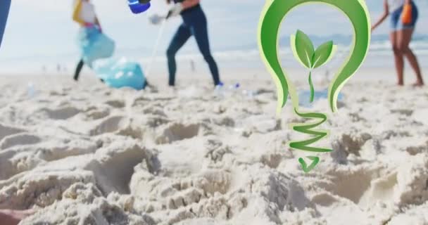 Animation Green Light Bulb Logo Diverse Group Picking Rubbish Beach — Stock Video