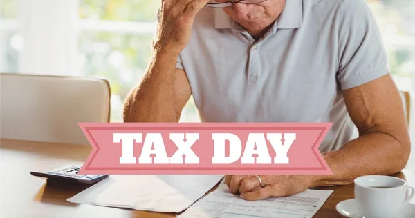 Tensed retired caucasian senior man sitting with financial bills at table behind tax day text. unaltered, people, emotions and finance concept.
