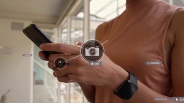 Akıllı telefon kullanan iki ırklı kadın üzerinden medya simgeleriyle bağlantı ağının animasyonu. Sosyal medya ve iletişim arayüzü kavramı dijital olarak oluşturulmuş video.