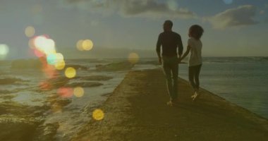 Afrika kökenli Amerikalı çiftlerin el ele tutuşmaları ve yürümeleri üzerine ışık noktalarının canlandırılması. yürüyüş günü ve dijital olarak oluşturulan video konsepti.