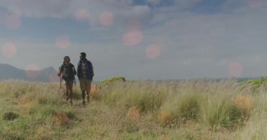 Dağlarda yürüyen engelli erkek ve kadının üzerindeki ışık noktalarının canlandırılması. yürüyüş günü ve dijital olarak oluşturulan video konsepti.