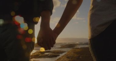 Kafkasyalı bir çiftin el ele tutuşup yürümesi üzerine ışıklı noktaların canlandırılması. yürüyüş günü ve dijital olarak oluşturulan video konsepti.