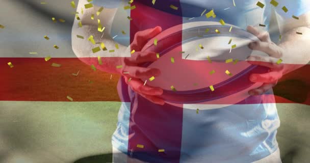スタジアムでボールを持つ白人男性ラグビー選手の上にイングランドとコンフェッティの旗のアニメーション スポーツやソーシャルメディアの概念をデジタルで — ストック動画