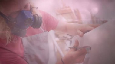 Beyaz tenli, gaz maskeli, kumaş kesen erkek işçinin üzerinde ışık lekeleri görülüyor. iş ve güvenlik kavramı dijital olarak oluşturulmuş video.