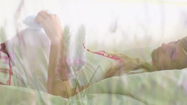 Mutlu, beyaz, hamile, bebek ayakkabılı bir kadın üzerinde çimen animasyonu. anne sağlığı farkındalık haftası konsepti dijital olarak oluşturulmuş video.