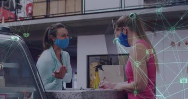 Yüzü maskeli iki beyaz kadın arkadaşın konuştuğu medya simgelerinin canlandırılması. Dijital olarak oluşturulan covid 19 pandemik konsept sırasında sosyal medya ve iletişim arayüzü.