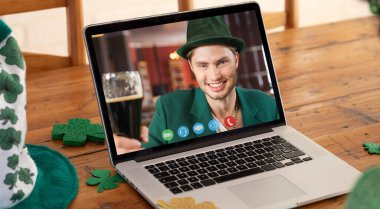 Kafkasyalı bir adam St. Patrick 'in günündeki videosunu izliyordu. Evde dizüstü bilgisayarda gülümseyen bira içiyordu. Karantina süresince evde tecrit edilmiş İrlandalı koruyucu azizlerin gününü kutluyoruz..