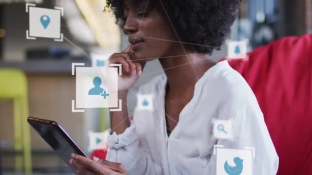 オフィスでデジタルタブレットを使用してアフリカ系アメリカ人女性に対するデジタルアイコンのネットワーク ビジネスと技術の概念 — ストック動画