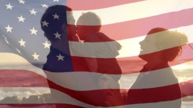 Amerika bayrağının plajda çocuklu beyaz ebeveynler üzerinde canlandırılması. Vatanseverlik ve kutlama konsepti dijital olarak oluşturulmuş video.