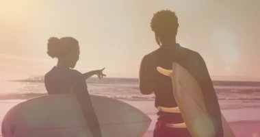 Sahilde sörf tahtası olan Afrikalı Amerikalı bir çiftin üzerindeki ışık noktalarının animasyonu. moda ve yaşam tarzı konsepti dijital olarak oluşturulmuş video.
