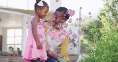 Kalp ikonlarının animasyonu mutlu Afrika kökenli Amerikalı anne ve kızının bahçıvanlığı üzerine. moda ve yaşam tarzı konsepti dijital olarak oluşturulmuş video.