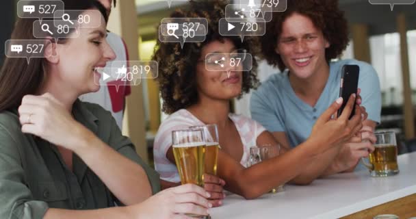 Анимация Медиа Икон Над Счастливыми Разнообразными Друзьями Использующими Смартфон Пивом — стоковое видео