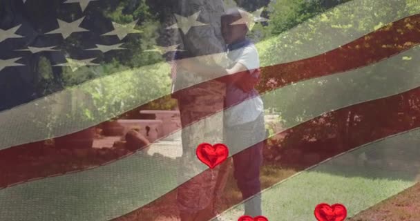 息子とアフリカ系アメリカ人男性兵士の上にハートアイコンとアメリカの旗のアニメーション ファッションやライフスタイルの概念をデジタルで — ストック動画