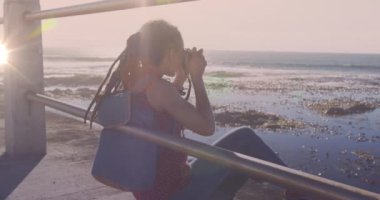 Gezinti güvertesinde kamerayla fotoğraf çeken melez bir kadının üzerindeki ışık lekelerinin canlandırması. sağlık ve zindelik kavramı dijital olarak oluşturulmuş video.