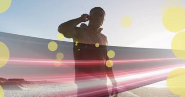 Sahilde kulaklıklı Afro-Amerikan bir adamın üzerinde benekler. sağlık ve zindelik kavramı dijital olarak oluşturulmuş video.