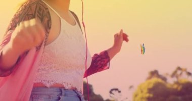 Kulaklıklı, gülümseyen beyaz kadın dans ederken gökkuşağı el ikonu. dans günü ve kutlama konsepti dijital olarak oluşturulmuş video.