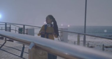 Gezinti güvertesinde scooter 'ıyla yürüyen gülümseyen melez kadının üzerindeki ışık lekelerinin canlandırması. sağlık ve zindelik kavramı dijital olarak oluşturulmuş video.